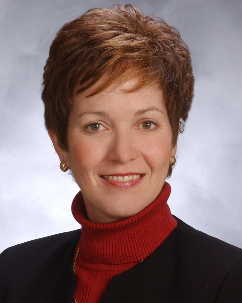 Board secretary, Margaret G. Brown. She is wearing a red turtleneck,